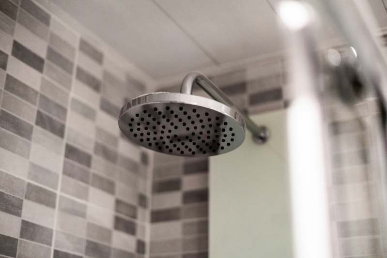 Blog team testing multiple shower heads on a bathroom wall rig